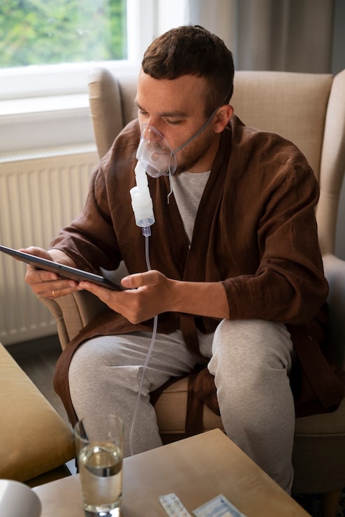 Professional photograph of a molecular hydrogen inhalation device with a patient comfortably wearing a soft nasal cannula — modern minimalist clinical setting with sage and warm cream tones, peaceful relaxed atmosphere