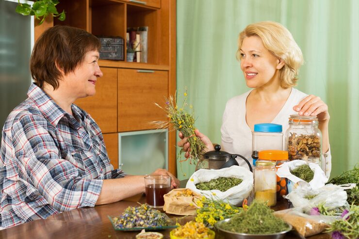 Lifestyle photograph of liver-supporting and detox-friendly whole foods, fresh herbs, and clean hydration arranged on a wooden surface — earthy natural tones with sage accents